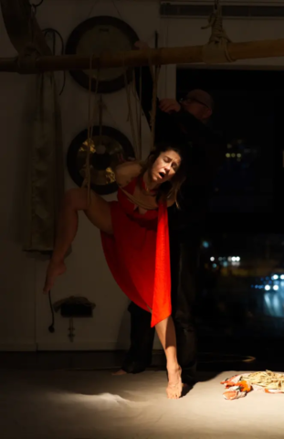 Visual representation of a Kinbaku Shibari Japanese Rope Bondage Performance by Alexander MA and Natasha NawaTaNeko in IKSK Berlin, Girl in red dress, sexpositive, conscious sexuality, couple